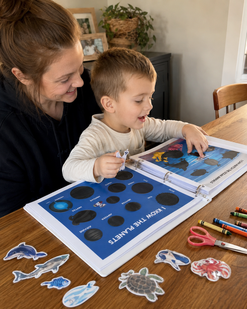Mother and little boy working on ocean animal and planet printables at home