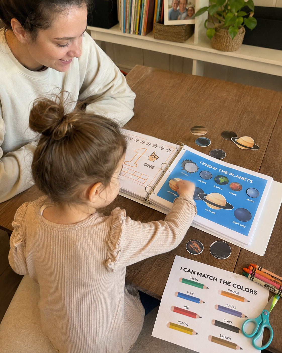 Mother and daughter matching printable planet pieces at the kitchen table